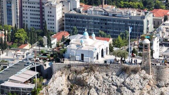 无人机在希腊雅典Lycabettus山上的圣乔治教堂上空飞行