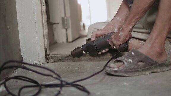 一个老人在家里用电钻做DIY
