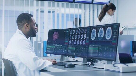 在实验室用个人电脑研究CT大脑扫描图像的医学科学家神经研究中心的神经学家研究脑肿瘤的治疗方法