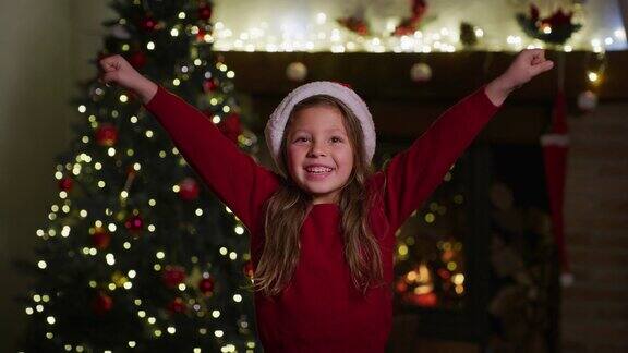 可爱开朗的小女孩戴着圣诞帽祝大家圣诞快乐的慢镜头