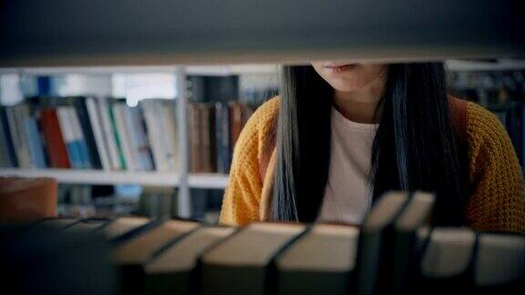 SLOMO在图书馆书架上找书的年轻女子