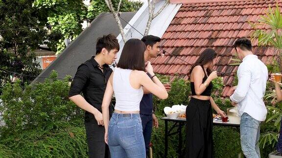 亚洲朋友在屋顶派对上享受饮料和食物