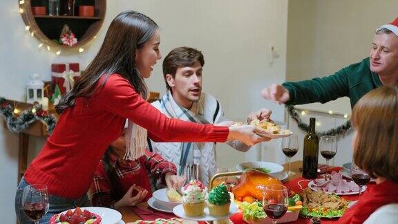 多民族大家庭在家里一起庆祝圣诞晚会吸引形形色色的人们在餐桌上吃着美食庆祝感恩节、圣诞夜的节日