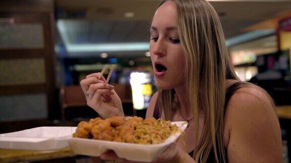慢镜头年轻女子吃着中餐外卖