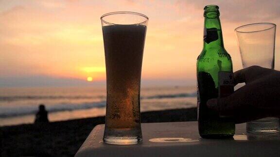 在海滩上啤酒被倒进玻璃杯中的慢动作镜头