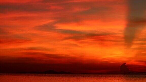太阳射线日落在红色的天空在暗橙色的云时间流逝