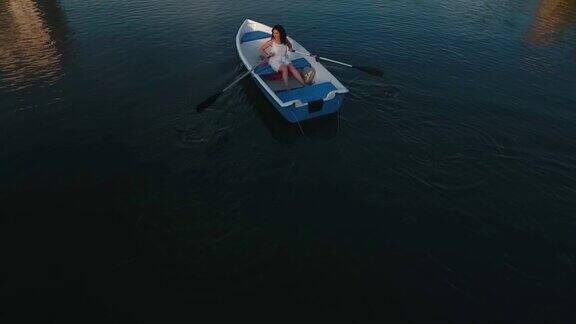 年轻女孩在湖上划船