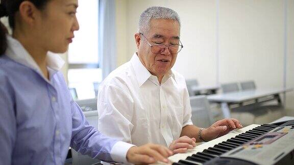 一位老人向一位女士学钢琴