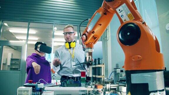 虚拟现实概念工程师正在教一个男孩操作机械臂