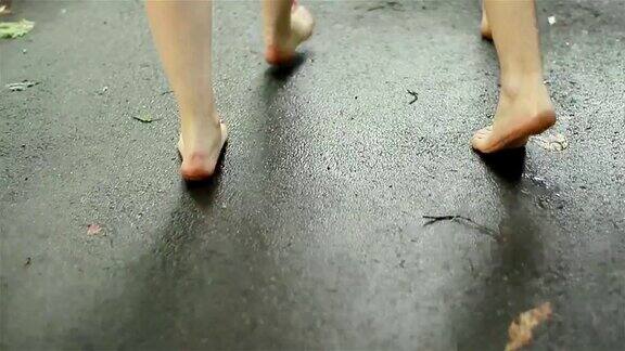 2个人赤脚走在秋天潮湿的路上腿的特写