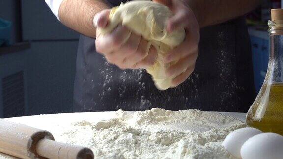 面包师用手揉面团在桌子上做披萨球面包生产过程面包店工作
