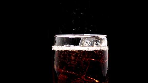可乐倒进装有冰块的杯子里泡沫溢出溢出杯沿黑色背景近距离