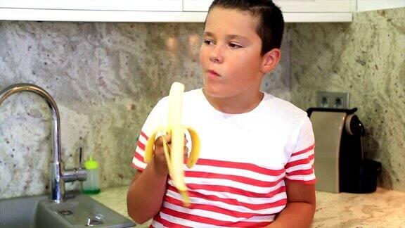 小男孩在厨房吃香蕉