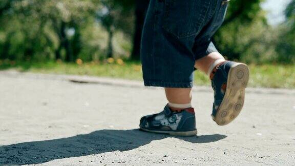 小男孩从父母身边跑开慢镜头里的幸福家庭近距离的腿