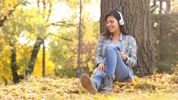 倚靠在树上听音乐的年轻女子