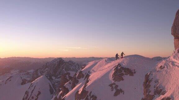 日出时分人们在白雪覆盖的山脊上行走