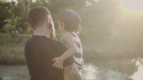 在日落森林里快乐的父亲抱着一个小男孩泰国