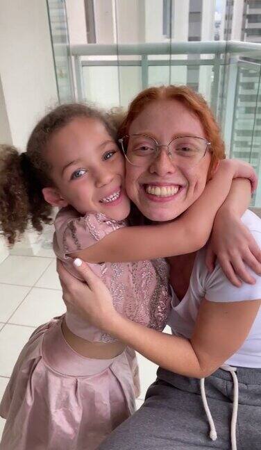 漂亮的红发年轻女子和她的小妹妹拥抱在一起