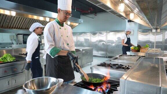 亚洲专业厨师在现代化厨房中烹饪美味佳肴