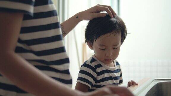 亚洲男婴帮助母亲做家务