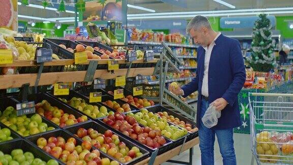 男性顾客在超市买苹果把水果放在塑料袋里4KProres