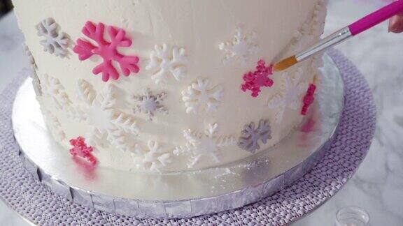 用粉红色和白色的软糖雪花装饰圆软糖蛋糕