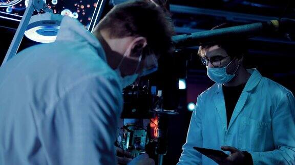 年轻的外科医生在实验室里做实验设备连接在一起科学家们穿着白袍戴着眼镜