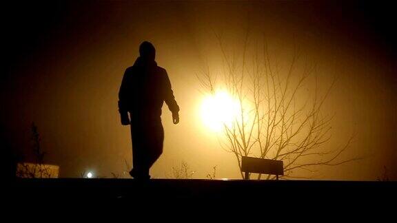 一个男人在雾蒙蒙的夜晚行走