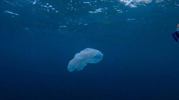 清洁海洋一名男子在海面下捕捉塑料袋