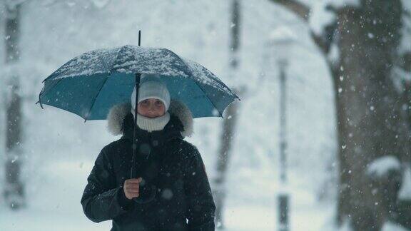 COPYSPACEPORTRAIT:女人在暴风雪中探索田园诗般的白色公园