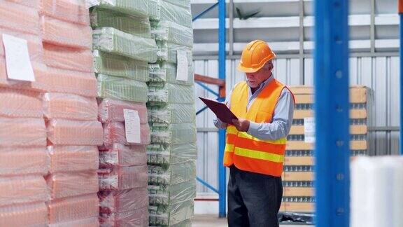 仓库或工厂里的高级工人正忙于自己的业务准备货物交付