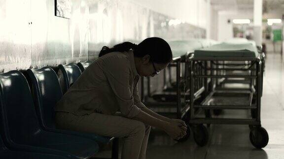 一个亚洲女人独自坐在医院里担心和焦虑从想到坏消息4K