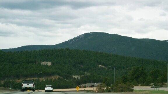252出口:EvergreenParkway(ColoradoHighway74)在多云的日子里在科罗拉多落基山脉70号州际公路上向西行驶的车辆的出口标志