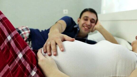 一个男人的手抚摸一个孕妇的大肚子的特写