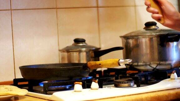 在家庭厨房的炉子上用平底锅做饭