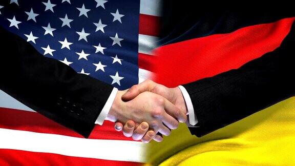 美国和德国握手国际友谊旗帜背景