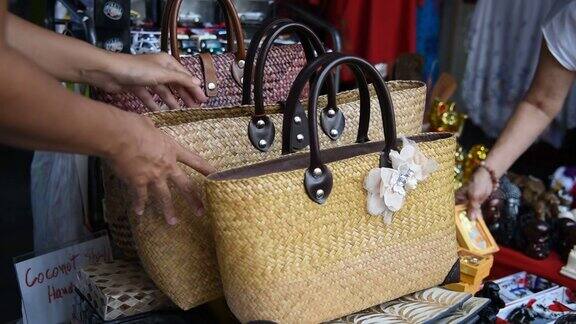 一名女性游客在泰国的纪念品商店选择手工包