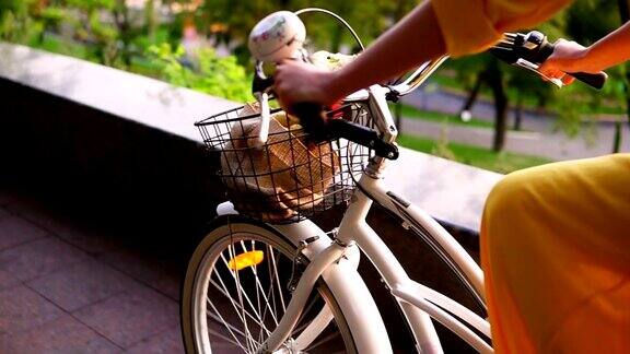 一个不认识的女人骑着一个篮子和花的城市自行车的特写替身Slowmotion