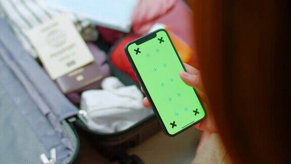 女士在打包行李时使用手机绿色屏幕