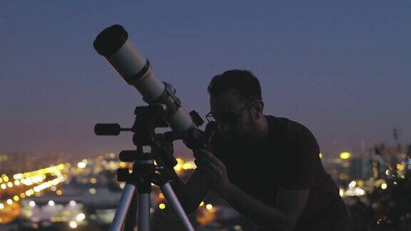 一个人的剪影望远镜和星空下的乡村
