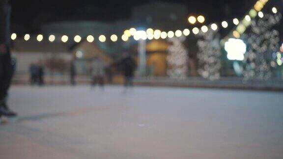 晚上在城市的露天溜冰场上一群不认识的人在骑着他们的腿圣诞集市上的公共溜冰场人们在乌克兰基辅的溜冰场上滑冰