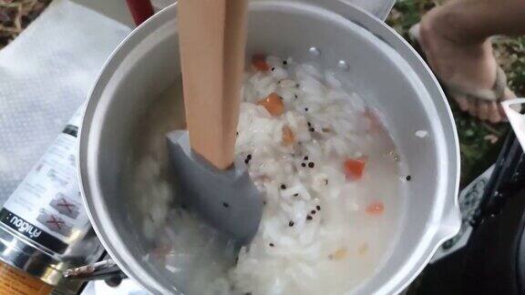 用米桨搅拌“Juk”(韩国米粥)烹饪户外露营