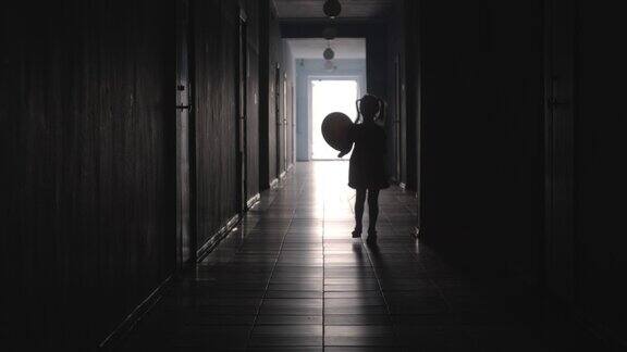 女孩带着气球沿着走廊跑的剪影