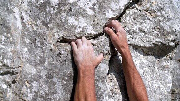 攀登者抓住岩石表面的裂缝