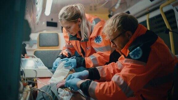女性和男性EMS护理人员提供医疗帮助受伤的病人在去医疗保健医院的路上急救助理在救护车上戴上无创通气面罩