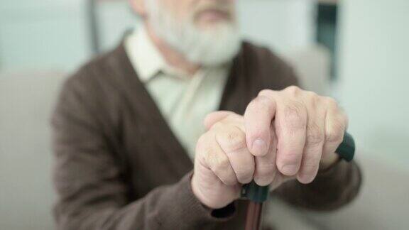 老年男性双手拄拐杖年老体弱居家护理身体健康