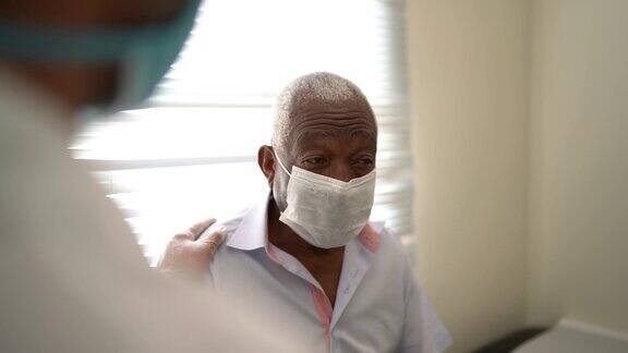 医生使用口罩给予老年病人情感支持