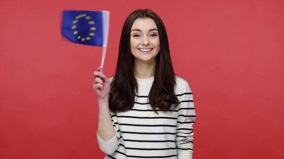 女性挥舞欧盟旗帜与欧盟旗帜一起欢呼庆祝国家大事