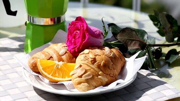 浪漫的早餐新鲜的羊角面包和一片橙子