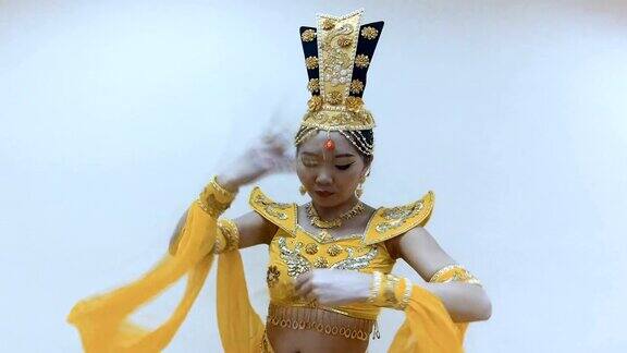 美丽的亚洲女人跳舞与手与长指甲美甲在传统的泰国黄色连衣裙